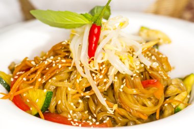 bir restoranda beyaz bir tabakta sebze ile pirinç makarna