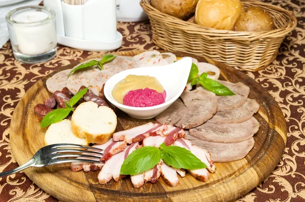 Teller mit Würstchen und Specksoße auf einem Tisch in einem Restaurant — Stockfoto