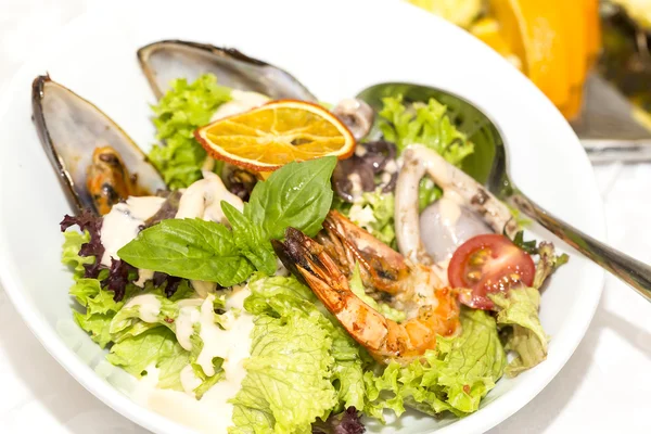 Meeresfrüchtsalat auf einem Teller auf weißem Hintergrund — Stockfoto