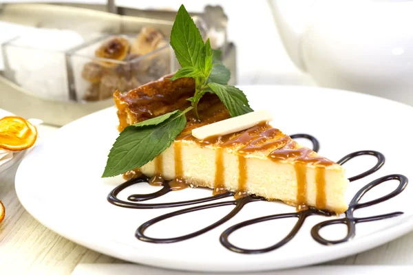 A piece of cheese cake decorated with mint — Stock Photo, Image