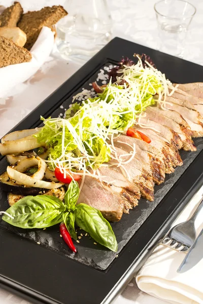 Carne grelhada com legumes na mesa em — Fotografia de Stock