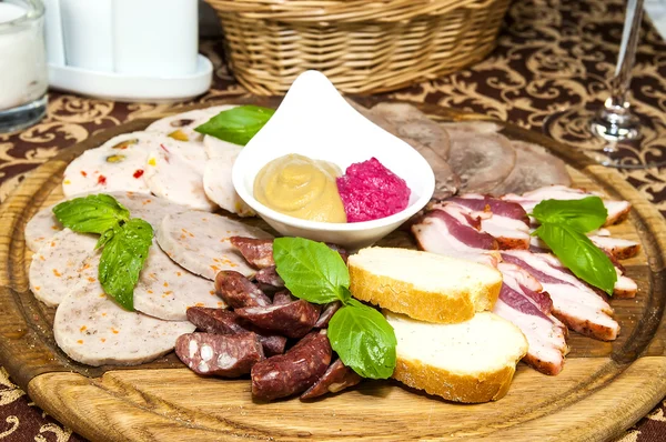 A plate of bacon and deli meats and sauce — Stock Photo, Image