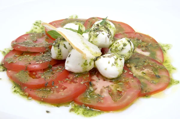 レストランで白いプレート上に注がれるチーズ添えトマト — ストック写真