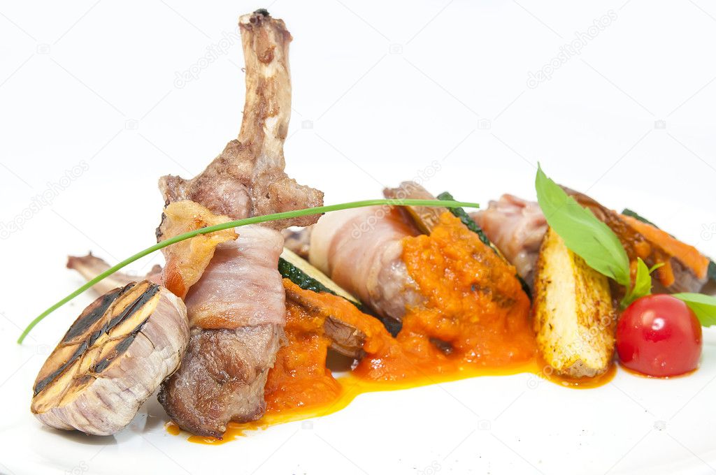 Roasted veal ribs with vegetables on a white plate
