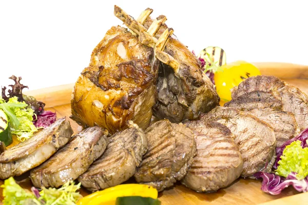 Loin and steak cooked on a grill with vegetables — Stock Photo, Image