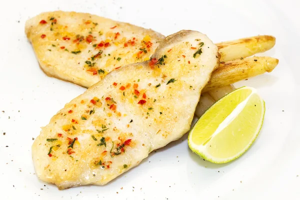 Sturgeon steak cooking on the grill with lemon and sauce — Stock Photo, Image