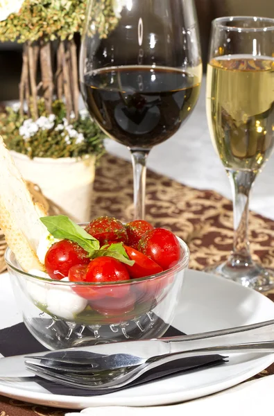 Tomatoes and cheese in a glass bowl — Stock Photo, Image