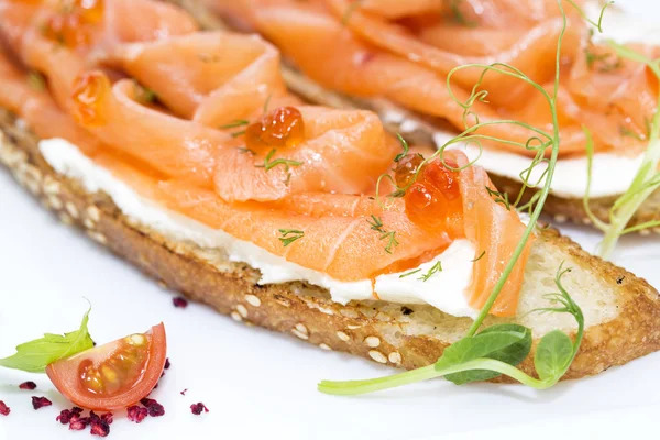 Sandwiches with salmon caviar and greens adorned — Stock Photo, Image