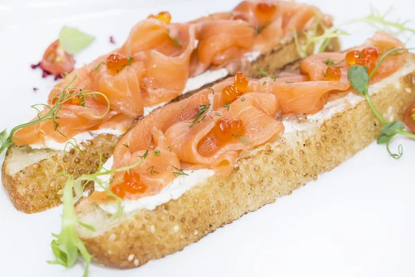 Sandwiches with salmon caviar and greens adorned — Stock Photo, Image