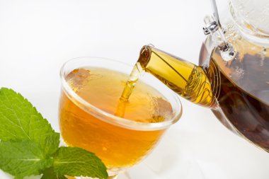 çay demlik beyaz bir arka plan üzerine dökülür.