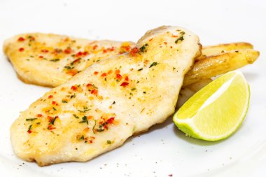 Mersin balığı biftek ızgara limon ve sos bir masada yemek