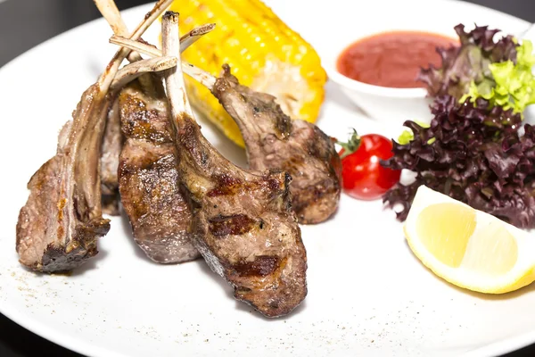 Costillas de ternera asadas con verduras en un plato blanco — Foto de Stock