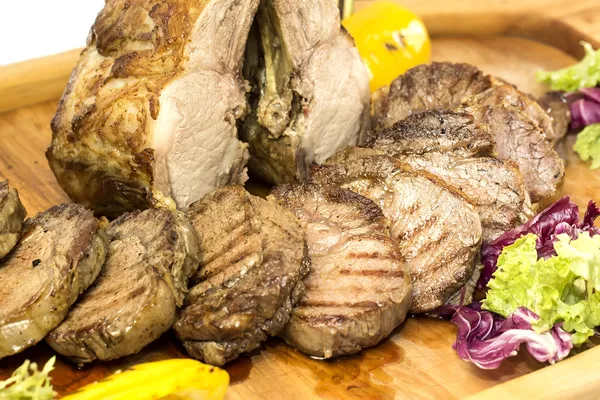 Lombo e bife cozidos em uma grelha com legumes — Fotografia de Stock