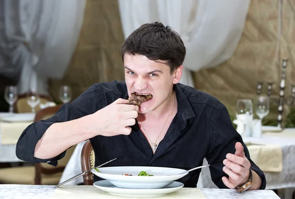 Junger Mann beim Abendessen — Stockfoto