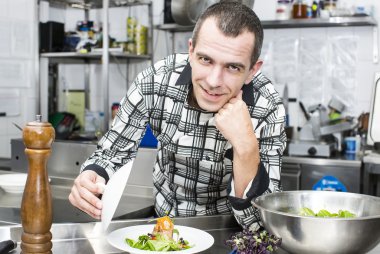 Şef mutfakta yemek hazırlıyor.