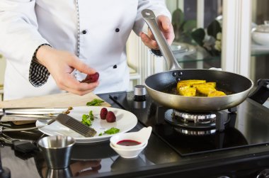 Şef mutfakta yemek hazırlıyor.