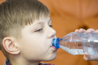 çocuğun suyu plastik şişeden içer.