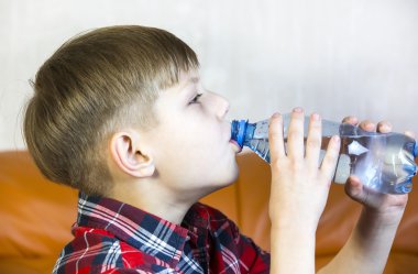 çocuğun suyu plastik şişeden içer.