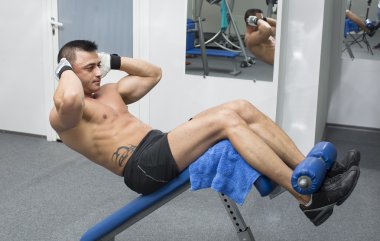 Genç adam spor salonunda antrenman yapıyor.