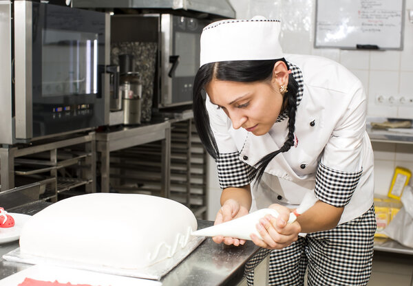 Pastry chef decorates a cake