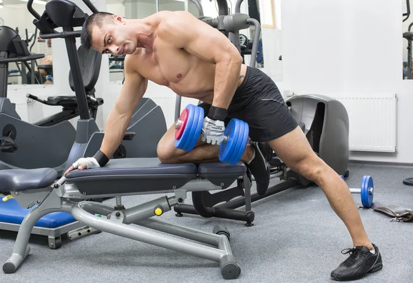 Junger Mann trainiert im Fitnessstudio — Stockfoto