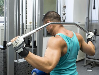 Genç adam spor salonunda antrenman yapıyor.