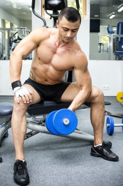 Genç adam spor salonunda antrenman yapıyor.