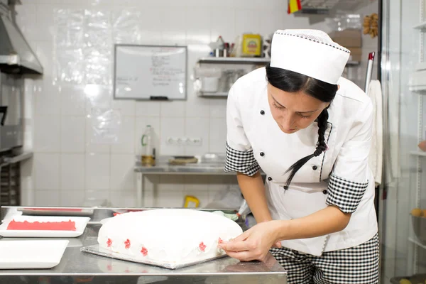 Chef de pastelaria decora um bolo — Fotografia de Stock