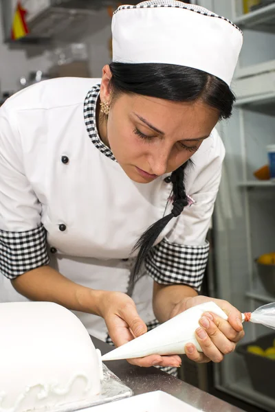 Pastry chef decorates a cake — Stock Photo, Image