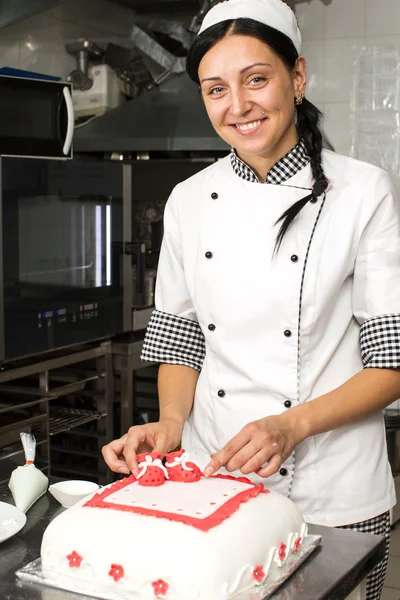 Pastry chef decorates a cake — Stock Photo, Image