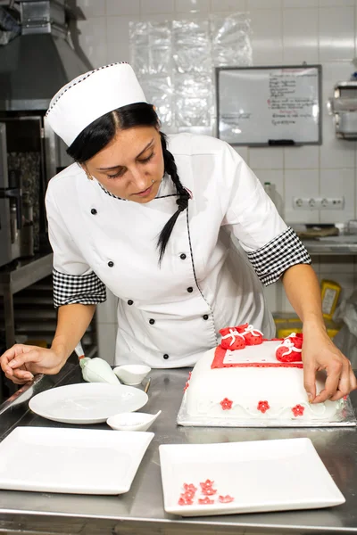 Pastry chef decorates a cake — Stock Photo, Image