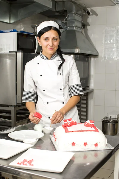 Pastry chef decorates a cake — Stock Photo, Image