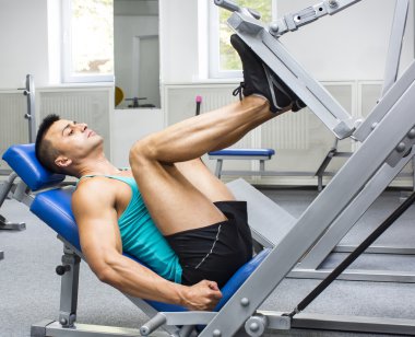 Genç adam spor salonunda antrenman yapıyor.