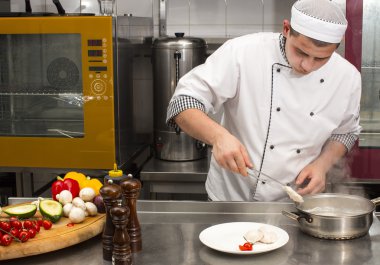 Şef mutfakta yemek hazırlıyor.