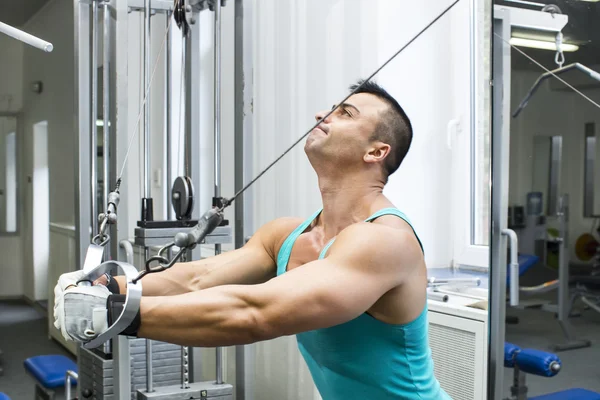 Jeune homme s'entraînant dans la salle de gym — Photo