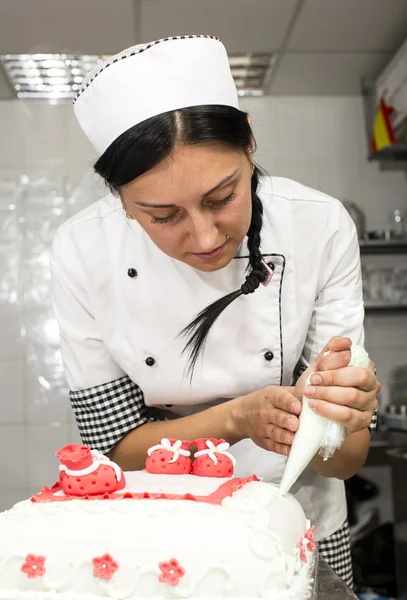 Pastry chef decorates a cake — Stock Photo, Image