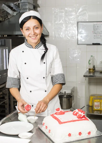 Pastry chef decorates a cake — Stock Photo, Image