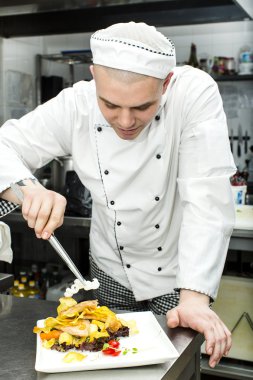 Şef mutfakta yemek hazırlıyor.