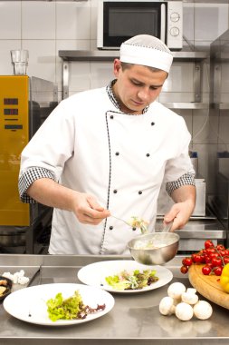Şef mutfakta yemek hazırlıyor.