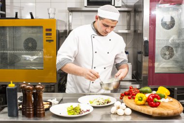 Şef mutfakta yemek hazırlıyor.