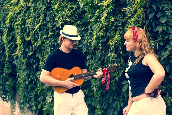 Tipo con una guitarra y una mujer — Foto de Stock