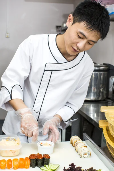 Chef japonés en restaurante haciendo rollos de sushi — Foto de Stock