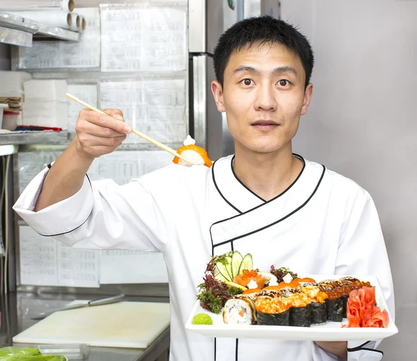 Japanse chef-kok met een plaat van sushi — Stockfoto