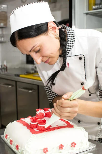 Pastry chef decorates a cake — Stock Photo, Image