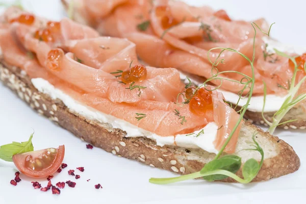 Sandwiches with salmon caviar and greens adorned — Stock Photo, Image