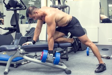 Genç adam spor salonunda antrenman yapıyor.