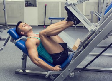 Genç adam spor salonunda antrenman yapıyor.