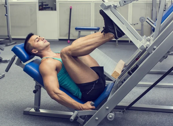 Genç adam spor salonunda antrenman yapıyor.
