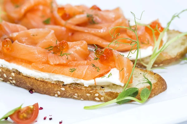 Sandwiches with salmon caviar and greens adorned — Stock Photo, Image