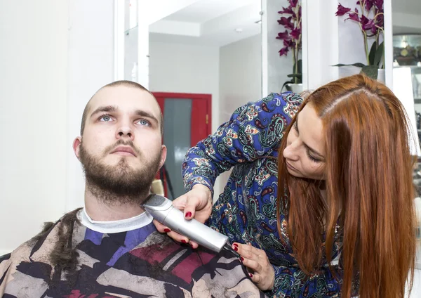 Жіночий перукар, що ріже волосся клієнта в салоні — стокове фото